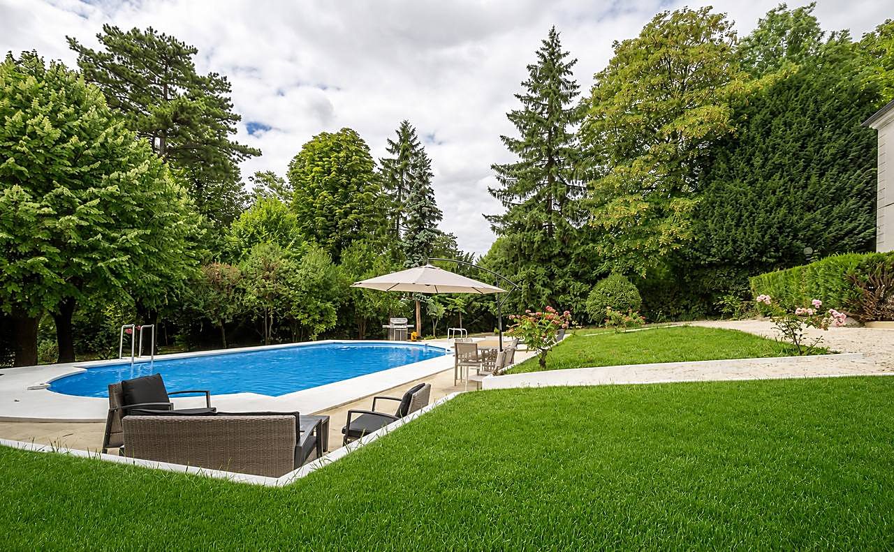 Piscine et pelouse dans le parc fleuri