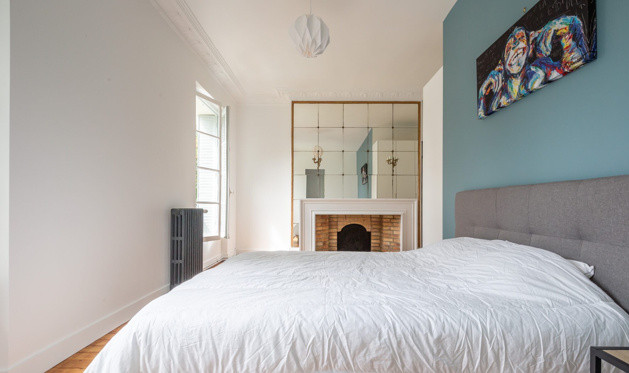 Chambre double avec cheminée de brique et mur bleu canard